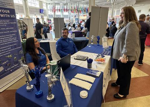 Cami Feek visits with workers at the Aero Controls booth at the job fair.
