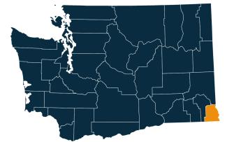 A dark blue map of Washington state with Asotin County highlighted in orange.