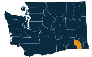 A dark blue map of Washington state with Columbia County highlighted in orange.