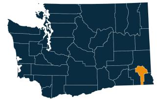 A dark blue map of Washington state with Garfield County highlighted in orange.