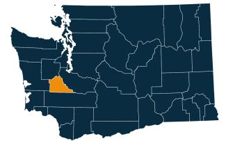 A dark blue map of Washington state with Thurston County highlighted in orange.