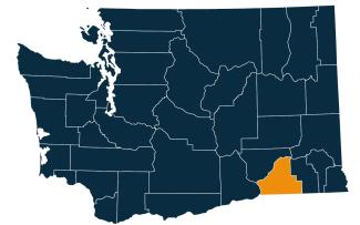 A dark blue map of Washington state with Walla Walla County highlighted in orange.