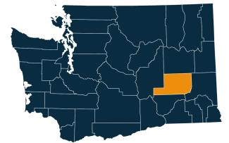 A dark blue map of Washington state with Adams County highlighted in orange.