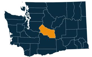 A dark blue map of Washington state with Kittitas County highlighted in orange.