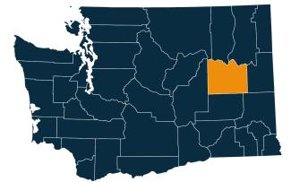 A dark blue map of Washington state with Lincoln County highlighted in orange.