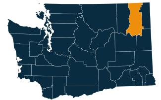 A dark blue map of Washington state with Stevens County highlighted in orange.