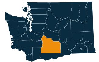 A dark blue map of Washington state with Yakima County highlighted in orange.