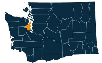 A dark blue map of Washington state with Kitsap County highlighted in orange.