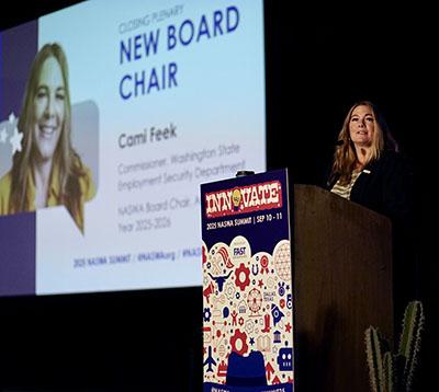 Commissioner Cami Feek speaks at a podium at a NASWA conference to accept her new position as NASWA board chair.